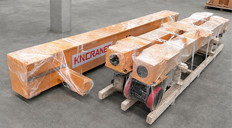 Portable gantry crane knocked down and film-wrapped on wooden pallets