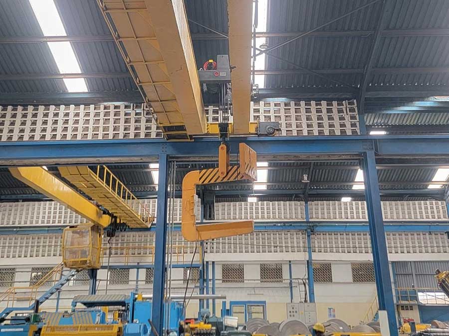 Upgraded double girder overhead crane with new hoist trolley and coil lifting C-hook in service at a Kenyan steel processing plant