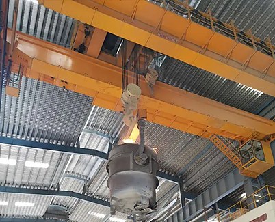 Ladle crane pouring molten metal in a foundry melt shop
