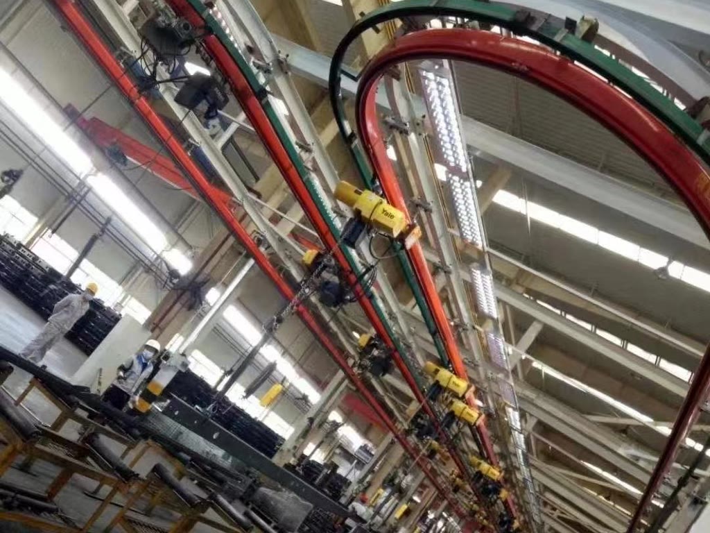 Closed-loop monorail crane line with several hoists above an assembly line