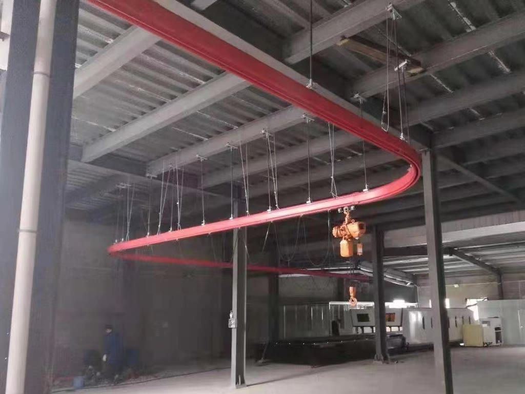 Curved monorail crane track suspended from roof steelwork