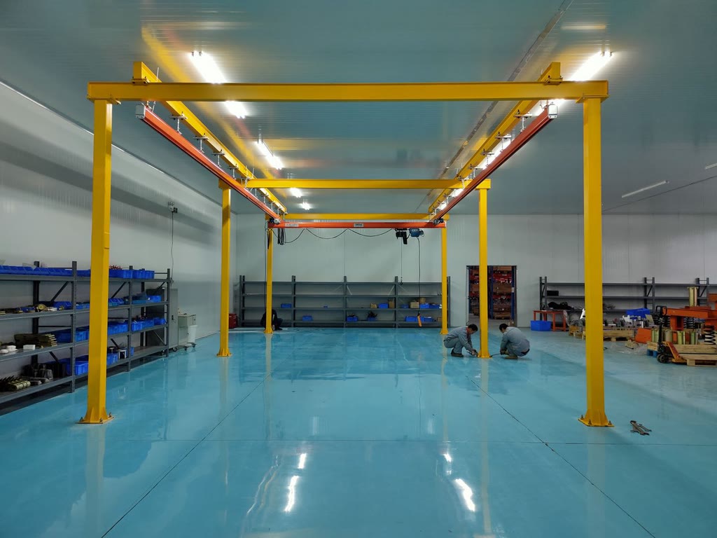 Single girder workstation crane on a free-standing steel frame